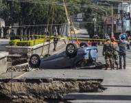 Socorristas y trabajadores sacan un vehículo de un hundimiento en el municipio de Villa Nueva uno de los más poblados de Guatemala.