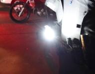 Foto referencial a un apagón. Un policía encendiendo una linterna en un sitio oscuro.