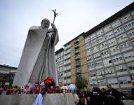 La gente reza ante la estatua de Juan Pablo II fuera del hospital Gemelli donde el Papa Francisco está hospitalizado en Roma el 24 de febrero de 2025. El Papa Francisco, hospitalizado en estado crítico por una neumonía, pasó bien la noche y se encuentra descansando, informó el Vaticano el 24 de febrero de 2025.