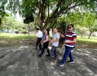 Personas con discapacidad visual en el parque La Rotonda, de Portoviejo.