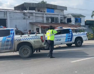 Imagen de un agente de tránsito haciendo señaléticas, observando el carro donde fueron atacados dos de sus compañeros, la tarde de este martes 19 de marzo.
