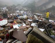 Vecinos caminan sobre los escombros generados por un deslizamiento de tierra este sábado, en Petrópolis, Río de Janeiro, Brasil.