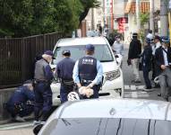 Agentes de policía investigan la escena en el distrito Nishinari de Osaka el 1 de mayo de 2025, después de que un hombre fuera arrestado por presuntamente embestir con su automóvil a siete escolares en un supuesto ataque deliberado, según informaron medios locales.