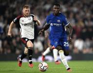 Moisés Caicedo conduce el balón contra la presión de un jugador del Fulham