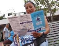 Una persona leyendo un folleto para informarse de la ordenanza de regularización de construcciones del Municipio de Guayaquil.