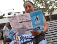 Una persona leyendo un folleto para informarse de la ordenanza de regularización de construcciones del Municipio de Guayaquil.