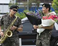 RM toca el saxofón junto a su compañero de banda V mientras tienen un encuentro con fans en Chuncheon, Corea del Sur.