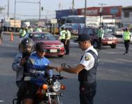 Agente de tránsito solicita documentos al conductor de una motocicleta en Durán.