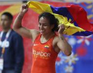 La ganadora de la medalla de oro, Luisa Valverde, de Ecuador, celebra con una bandera de su país tras ganar en lucha libre de 57 Kg de los vigésimos Juegos Bolivarianos este lunes, en Lima (Perú).