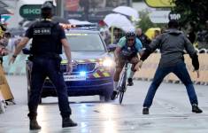 Personal de seguridad se prepara para detener a un aficionado en bicicleta antes de la meta, en la 17ª etapa del Tour de Francia, disputada el pasado miércoles, en Valence (Francia).