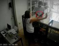 La empleada del lugar lo atendía cuando de pronto sacó un arma con la que la sometió. Captura de video