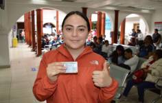 Una ciudadana muestra su nueva cédula de identidad.