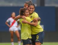 La jugadora de la selección de fútbol femenino de Ecuador, Emily Arias (i), celebrando el primer gol anotado a la selección femenina de Perú.