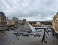 Esta fotografía muestra a visitantes, vistos desde el ala Sully, haciendo fila en la Cour Napoleon, junto a la pirámide diseñada por el arquitecto chino-estadounidense Ieoh Ming Pei, para entrar al Museo del Louvre en París el 19 de noviembre de 2025.