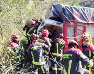 Elementos de los bomberos ayudan al conductor de un camión.