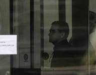 Fotografía que muestra al expresidente de Brasil Jair Bolsonaro (d) detrás de una puerta de vidrio este domingo, en la Superintendencia de la Policía Federal en Brasilia (Brasil).