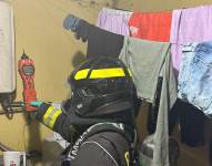 Un bombero inspecciona la conexión del calefón.
