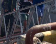 Foto de dos de los tres hombres detenidos con un fusil en el Golfo de Guayaquil, el lunes 1 de septiembre.