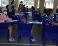 Niños esperan para recibir la vacuna contra COVID-19 en una escuela en Guayaquil, Ecuador.