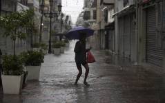Personas caminan por calles inundadas debido al paso de la tormenta tropical Franklin en Santo Domingo, República Dominicana