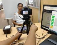 Una ciudadana es fotografiada antes de la emisión del pasaporte.