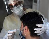 Personal médico le toma la prueba de coronavirus a un hombre en Río de Janeiro (Brasil).