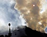 Fotografía de una columna de humo ocasionada por un incendio forestal hoy, en el cerro El Cable, en Bogotá (Colombia).