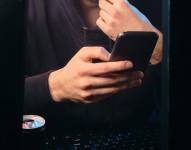 Imagen referencial para graficar a una persona que revisa su celular.