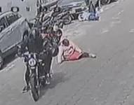 La víctima en el piso mientras huyen en motocicletas con el dinero.