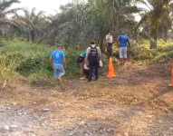 Imagen de ciudadanos y policías revisando el área donde fue abandonado el cuerpo de un locutor de radio, el domingo 24 de marzo, en Shushufindi. Sucumbíos.