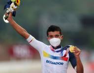 Richard Carapaz celebrando en el podio con su medalla de oro.