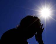 Imagen de una persona sufriendo de calor ante un sol intenso.