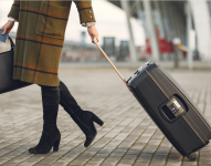 Imagen referencial de mujer con su maleta y su bolso.