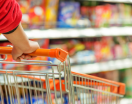 Persona con carrito de compras en supermercado.