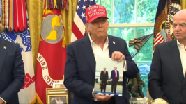 Donald Trump muestra una foto de él junto a Putin