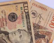 Imagen referencial de billetes de dólares y pesos colombianos.