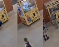 Niño en maquina de peluches