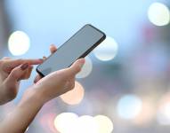 Imagen referencial de mujer con su dispositivo móvil.