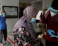 Los residentes de una urbanización pública hacen cola para las pruebas obligatorias de coronavirus en Singapur el 21 de mayo de 2021