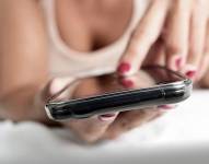 Imagen referencial de una mujer usando su celular.
