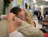 Una madre abraza a su hijo la llegada de este a Nueva York desde Reino Unido.