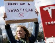 Una mujer protesta contra Tesla y Elon Musk en Reino Unido.