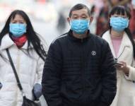 Personas en China usan mascarilla