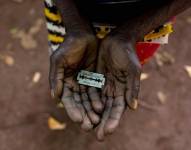 Una mujer de Mombasa, Kenia, conocida como una mutiladora , muestra la hojilla de afeitar que usa en los genitales de niñas.