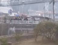 Momento en el que encapuchados rompen una tubería de agua en Ibarra.