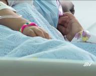 Imagen de una bebé sosteniendo la mano de su madre, en un hospital de Guayaquil.