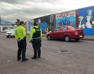 Dos policías custodian el automóvil en donde fue localizado el cadáver.