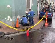Personal de la Empresa Eléctrica Quito trata de ingresar a las alcantarillas.