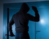 Imagen referencial de un delincuente que trata de ingresar a un local comercial.