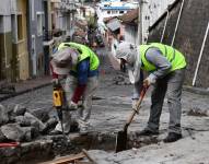 Dos obreros retiran las piedras en la calle Benalcázar en el Centro Histórico.